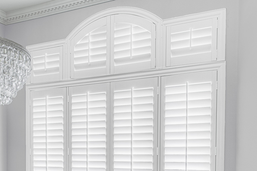 Customize your Palladian windows with white Polywood shutters in San Antonio. White Polywood Palladian windows in a dining room.