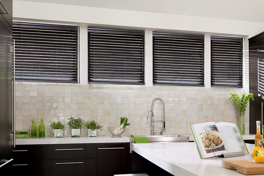 Choose custom Polywood faux wood blinds for your kitchen in San Antonio. Special shaped faux wood blinds in several windows above a sink.