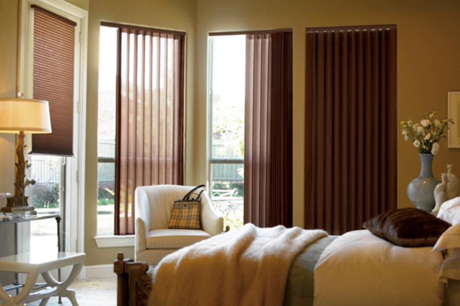 Choose durable and high-quality fabric or vinyl vertical blinds in San Antonio. Maroon fabric vertical blinds inside a bedroom